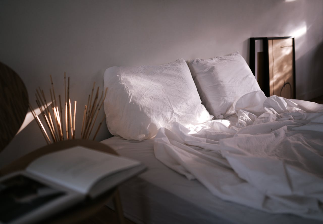 A serene bedroom scene showcasing soft linen, pillows, and ambient natural light, creating a calm atmosphere.